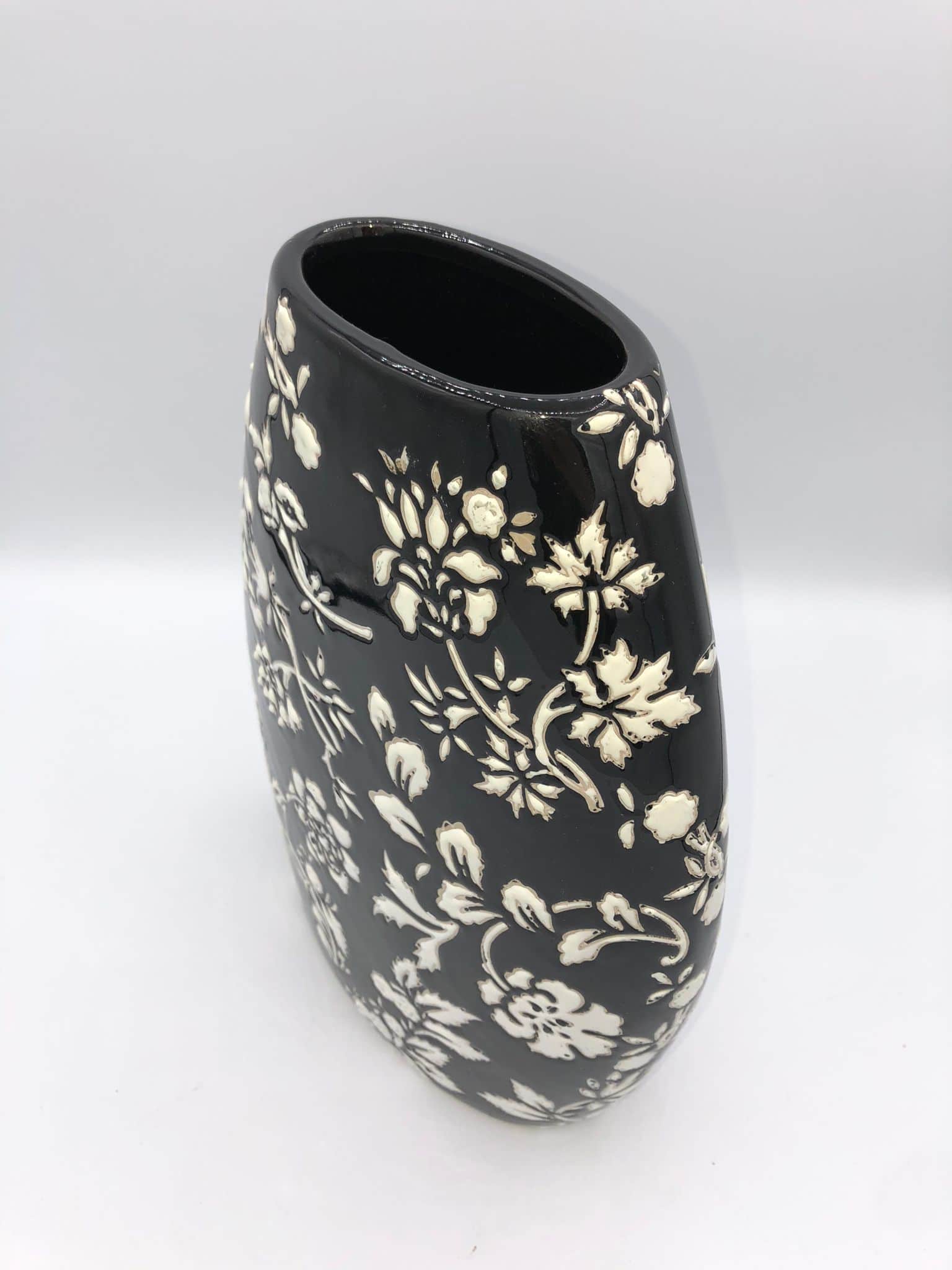 Jarrón de porcelana color negro con flores blancas